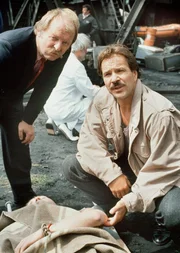 Thanner (Eberhard Feik, r.) und Schimanski (Götz George) am Tatort:  Der Tote war als Mittelsmann in Sachen ilIegaler Kunsthandel tätig und wird von der Ost-Polizei gesucht.