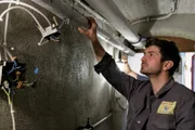 Valentin Guga (Jon Kiriac) prüft einen Schaden im Keller von Angelika Lorenz.