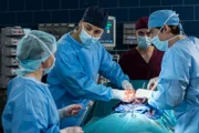 ARD PROGRAMMDIREKTION, IN ALLER FREUNDSCHAFT - DIE JUNGEN ÄRZTE, neue Vorabend-Weekly, Folgen 18 "Tiefe Wunden", am Donnerstag (11.06.15) um 18.50 Uhr im Ersten. Dr. Moreau (Mike Adler, 2.v.l.) und Ben Ahlbeck (Philipp Danne, r.) kämpfen im OP um Simon Heidkamps Leben. Dr. Moreau schafft es nicht allein und fordert einen weiteren Operateur an. (mit Komparsen)