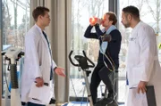 Weil seine Gesundheits-App ihm einen Herzinfarkt attestiert, kommt Tilman Klose völlig außer sich ins JTK. Matteo (Mike Adler, r.) und Mikko (Luan Gummich, l.) nehmen Tilman Klose (Felix P. Lehrmann, M.) genauer unter die Lupe.
