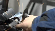 Der Mechaniker schneidet das Metallteil.