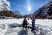 Jan Fitze und Camping-Chef Peter Käch bohren ein Eisloch.