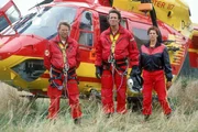 Peter Berger (Serge Falck, li), Dr. Harland (Urs Remond) und Biggi Schwerin (Sabine Petzl) warten vor dem Medicopter auf den vermißten Thomas Wächter. Schafft er es noch früh genug aus dem brennenden Bergwerkstollen zu fliehen?