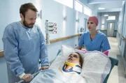Ansgar (Matthias Ziesing, l.) erwischt Lea (Charlotte Puder, M.) gerade noch auf dem Weg zum OP. Er spricht ihr gut zu und will auf sie warten (mit Mirka Pigulla, r.).