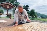 Geun Bum Sunim legt blanchierte Lotuswurzeln zum Trocknen aus.