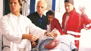 Fred Krüger (Burkhard C. Kosminski, 2.v.l.) hat Dr. Stefan Frank (Sigmar Solbach, l.) gerufen, als sein Vater (Gerd Fitz, lieg.) zusammengebrochen ist (Notärzte Komparsen).