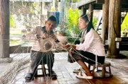 Im Traditionsmuseum von Luang Prabang, der alten Königsstadt des laotischen Reiches, stellt Touly gemeinsam mit einem erfahrenen Flechtmeister ein Rattanobjekt für die Ausstellung her.