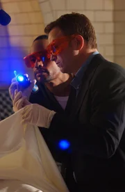 Detective Mac Taylor (Gary Sinise, r.) und Dr. Sheldon Hawkes (Hill Harper, l.) untersuchen eine Spur unter dem UV-Licht ...