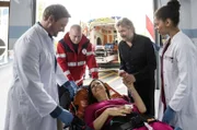 Nancy Lenz (Elisabeth Baulitz, M.) und ihr Mann Kai (Jörg Witte, 2.v.r.) sind unter Alkoholeinfluss zusammen eine Treppe hinuntergestürzt. Dr. Marc Lindner (Christian Beermann, l. mit Komparse, 2.v.l.) und Vivienne Kling (Jane Chirwa, r.) kümmern sich um die erheblich verletzte, aber gut gelaunte Nancy.