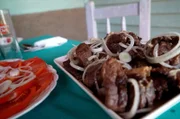 Auf Kuba wird das in trockenen Wein und Apfelsinen eingelegte und mit einer Knoblauchpaste eingeriebene Lamm in Schweinefett gebraten, mit Rotwein abgelöscht und dann mit Zwiebeln serviert.