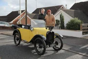 Presenter Tim and Fuzz standing next to the Austin 7.