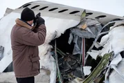 A member of the team (played by a background actor) photographs the wreckage of Continental Airlines flight 1713.