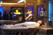 Dr. Peyton Driscoll (Claire Forlani) macht Beweisfotos von einer männlichen Leiche.