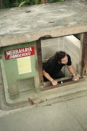Penang, Malaysia: RJ climbs up an escape tunnel in Penang War Museum.