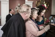 Mrs McCarthy (Sorcha Cusack, M.), Father Brown (Mark Williams, l.) und Bunty (Emer Kenny, r.) bewundern die detailgetreue Darstellung der Morde in den Dioramen. Noch ahnen sie nicht, dass es bald zu einem weiteren Mord kommen wird.