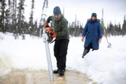 Chris Morse benutzt seine Kettensäge, um zusammen mit seiner Frau Jessi Morse Eisblöcke für Trinkwasser zu gewinnen. (National Geographic/Patrick Henderson)