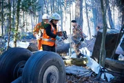 Investigator Bob Benzon (played by Kevin Carter) and recovery workers (played by background actors) recover the black boxes from Alitalia flight 404.