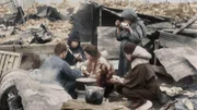 Familie in den Trümmern der bombardierten Stadt.