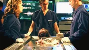Von links: Lindsay (Anna Belknap), Dr. Hammerback (Robert Joy) und Mac (Gary Sinise) obduzieren den abgetrennten Schädel der ermordeten Studentin.