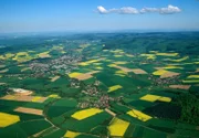 Frühling im Weserbergland: Wie gelbe Farbtupfer erscheinen die Rapsfelder aus der Vogelperspektive in der reich strukturierten Landschaft.
