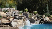 Peek Pools and Spas added a slide and rock work to the pool, as seen on Pool Kings.