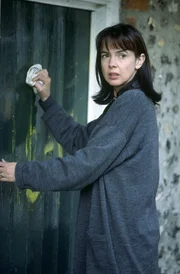 Laura Smythe-Webster (Phoebe Nicholls), die Mutter des getöteten Larry, versucht verzweifelt die Schmierereien an der Tür zur Sonntagsschule zu entfernen, die ihr ein Verhältnis mit einem der Brüder ihres Mannes andichten.