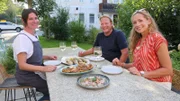 Regionale Spezialitäten im Fokus: Tamina Kallert (r) und Björn Freitag bei Renke und Kaspressknödel mit Köchin und lokaler Expertin Vroni Lutz (l) in ihrem Restaurant.