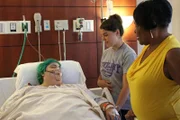 Paula sleeping on the hospital bed with her family and friends by her side.