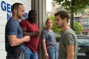 Romain Sauvant (Soufiane Guerrab, r.) spricht in einer Pause vor der Polizeistation mit Camille Delorme (Florence Janas, 2.v.r.), Ruben Sadri (Bruce Dombolo, 2.v.l.) und einem weiteren Teammitglied (Komparse) über das weitere Vorgehen im Fall Lily.
