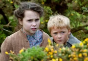 WDR Fernsehen CHARLOTTE LINK - DAS ANDERE KIND, Teil 1. Fiona (Chloe Jayne Wilkinson) und der kleine Brian (Haydn Cavanagh) beobachten das Treiben eines brutalen alten Bauern.