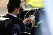 Ein Mann hält Uno-Karten, während er in einem Auto sitzt