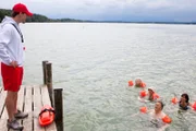 Polizeirat Girwidz (Michael Brandner, 2. von rechts) beim Schwimmkurs, der von Jürgen Kühn (Martin Kaps, links) geleitet wird.