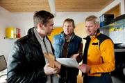 Andreas Marthaler (Martin Gruber, r.), Chef der Bergrettung, warnt Thomas (Manou Lubowski, l.) und Christian (Oliver Clemens, M.), dringend davor, in die Berge zu gehen, da ein Unwetter naht.