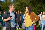 Julian (Ben Münchow, 3.v.l.) und Marie (Tinka Fürst, 3.v.r.) diskutieren mitten im Chaos des Schulausflugs, während die Schüler im Hintergrund langsam die Geduld verlieren. (Komparsen im Bild)