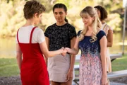 Elfe Imogen (Elizabeth Cullen, l.) und Fee Lily (Mia Milnes, 2.v.r.) besiegeln mit einem Handschlag das Ergebnis ihrer Wette. Sie hatten darum gewettet, wer zuerst einen Zauber der jeweils anderen beherrscht.
