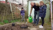 Unter den wachsamen Augen seiner Kids Kalli und Lara pflanzt Frank einen neuen Baum.
