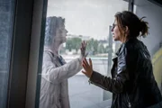 Johanna "Joe" Haizinger (Katharina Stemberger, l.) steht außen vor einem Fenster frontal Inga Feta (Marie Hacke, r.) gegenüber. Inga versucht Johanna etwas sehr dringlich mitzuteilen.