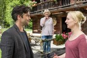 Oliver Mertens (Xaver Hutter, l.) freut sich, dass er in Inga Lohmeyer (Cordula Zielonka, r.) einer so charmanten Verkäuferin von Schnitzereien gegenüber steht. Ingas Mutter Elisabeth (Saskia Vester, M.) verfolgt das Gespräch der beiden, kann sie aber nicht hören.