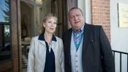 Wintrichs Frau Bärbel (Marina Krogull, l.) hat von dem Einbruch nichts mitbekommen - sie und ihr Mann schlafen schon lange in getrennten Betten. Bärbel erklärt, dass sie nur bei Holger geblieben ist, weil sie bei einer Scheidung leer ausgegangen wäre. Wollte sie den ungeliebten Mann loswerden und sein Vermögen erben? Jan Reuter (Udo Kroschwald, r.) ermittelt.