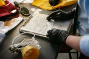 ONTARIO - RE-ENACTMENT - NTSC Investigator (played by Redd Ochao) takes notes at the hanger.