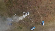 Auf einem Feld liegen die Wrackteile eines abgestürzten Sportflugzeugs. Aus einigen Teilen steigt vereinzelt Rauch hoch. Im Wrack liegt die Leiche des Piloten Philip Franke. Die Kriminalpolizei trifft am Tatort ein.
