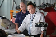 ONTARIO - RE-ENACTMENT - NTSC Investigator (played by Redd Ochao) finds something curious in the pieces obtained from the plane crash. The BEA agent (played by a background performer) stands by and observes.