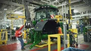 John Deere tractor being constructed in factory.