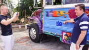 Reiseleiter Bernd und Kreuzfahrtdirektor Thomas Gleiß (rechts) fahren mit einem bemalten Oldtimer-Schulbus durch Panama City. Thomas Gleiß lässt sich von Bernd mit dem Bus fotografieren.