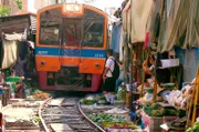 Spektakuläre Touristenattraktion: Achtmal am Tag tastet sich in Samut Songkhram (Thailand) ein Nahverkehrszug mitten durch einen Lebensmittelmarkt. Die Händler müssen dazu ihre Stände beiseite räumen.
