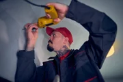Ein Handwerker (Mariano Vivenzio) macht sich an der Wohnungstür von Caro und Yannik zu schaffen.