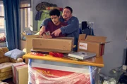 Tüffi (Daniel Zillmann, r.) zeigt Yannik (Rojan Juan Barani, l.), wie man ein Paket ordnungsgemäß frankiert.