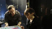 Wendy (Liz Vassey) betrachtet das kriminalistische Brettspiel, das Hodges (Wallace Langham) entwickelt hat und hat dabei einige Fragen an den undurchsichtigen Labortechniker.