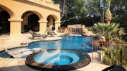 The top-tier of the Larson pool is complete with an oversize spillway spa, Baja shelf, waterfall, grotto, infinity edge, and ample entertaining space  on a travertine deck.