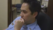 Der Polizist setzt sich auf einen Stuhl und denkt nach